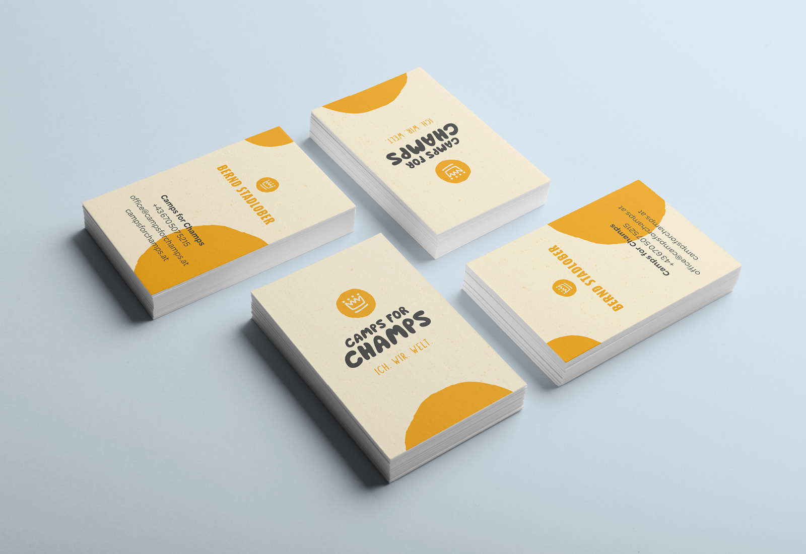 A set of business cards with vibrant yellow and orange designs.