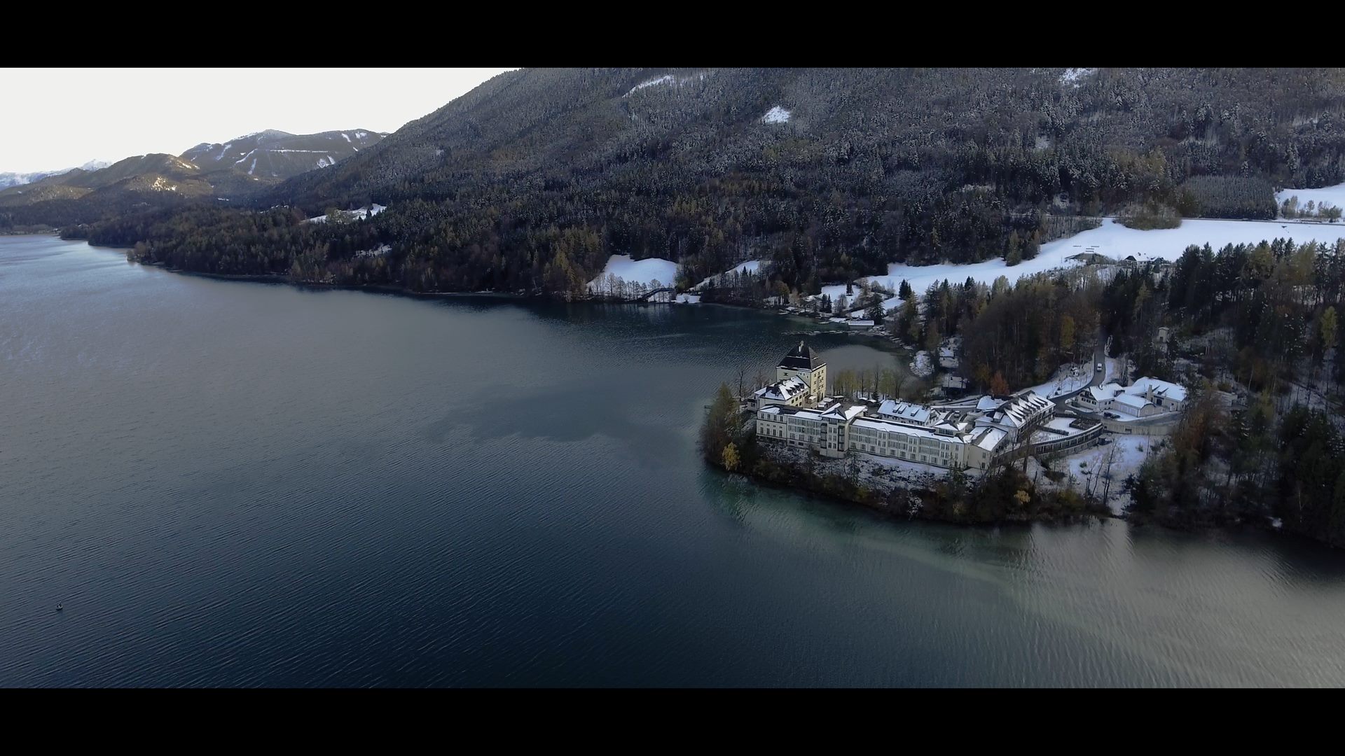 Eine Luftaufnahme eines Sees mit einem Sheraton Hotel darauf.