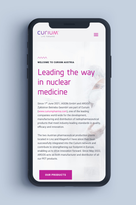 Ein Mobiltelefon, auf dem die Website des Nuklearmedizinunternehmens Curium Pharma angezeigt wird.