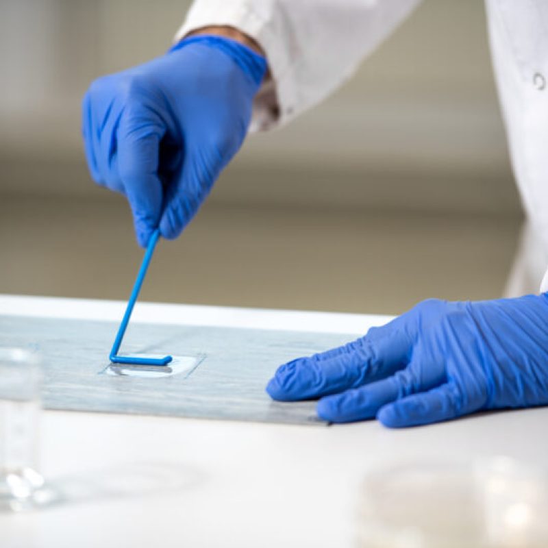 A scientist in a lab coat is preparing an OFI sample.