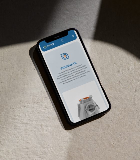 A smartphone displaying a mobile app on a concrete surface with PMT. A smartphone displaying a mobile app on a concrete surface with PMT.