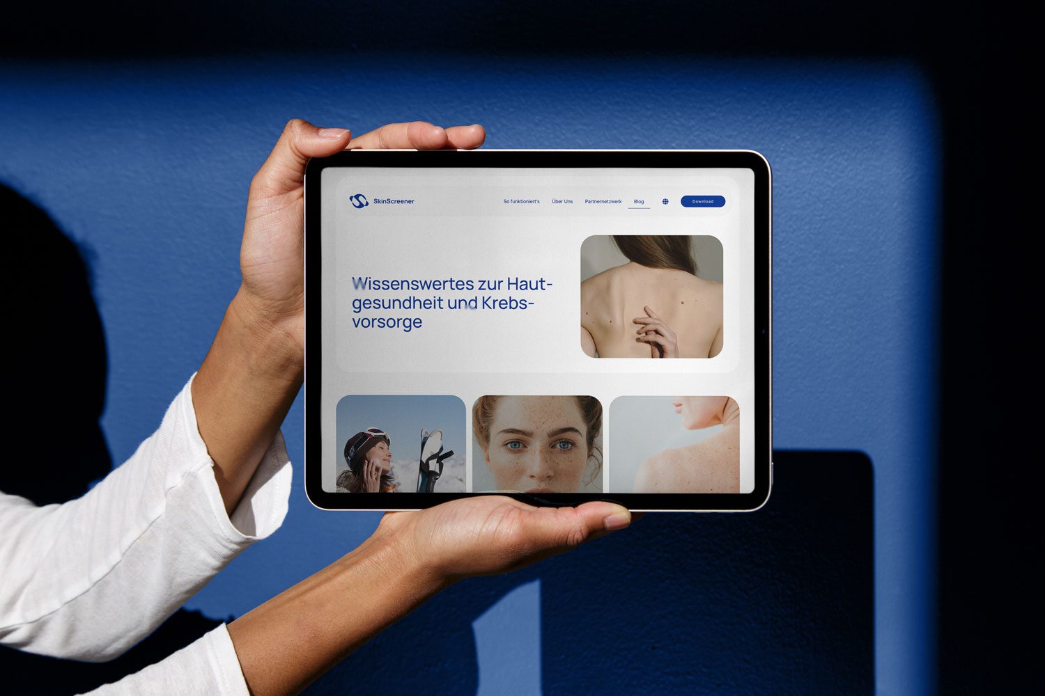 A woman is using a SkinScreener app on an iPad to analyze images of her skin.