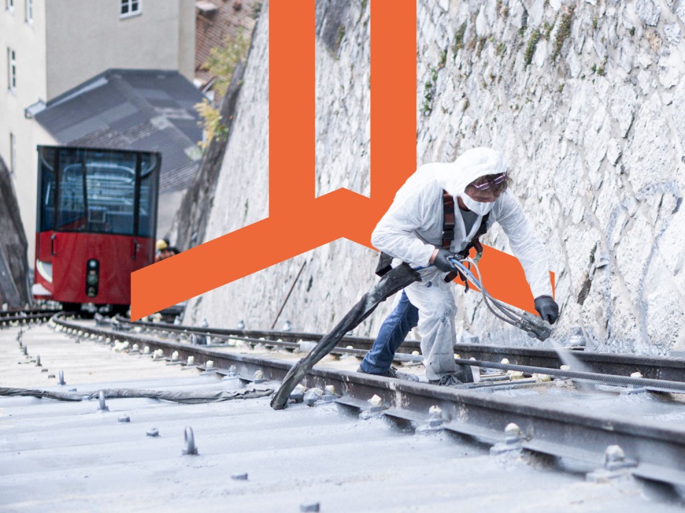 A man in a white jacket is working on a Polyflex train track.