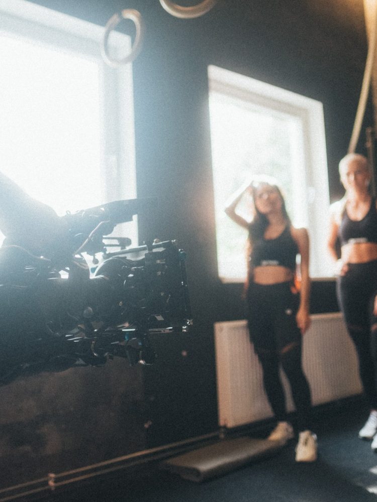 Eine Gruppe von Frauen steht in einem Fitnessstudio vor einer Kamera.