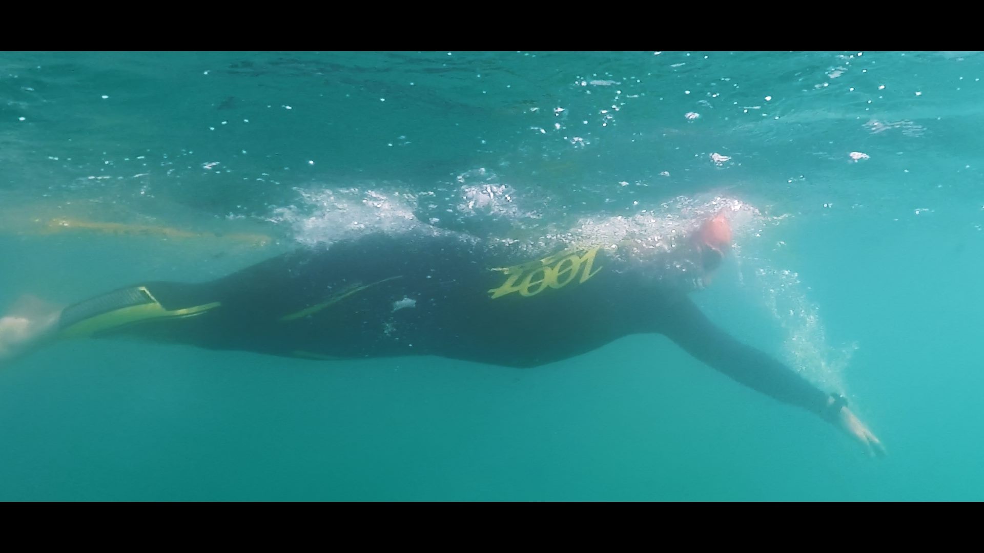 Ein Mann im Neoprenanzug schwimmt im Meer bei den Austria Swim Open.
