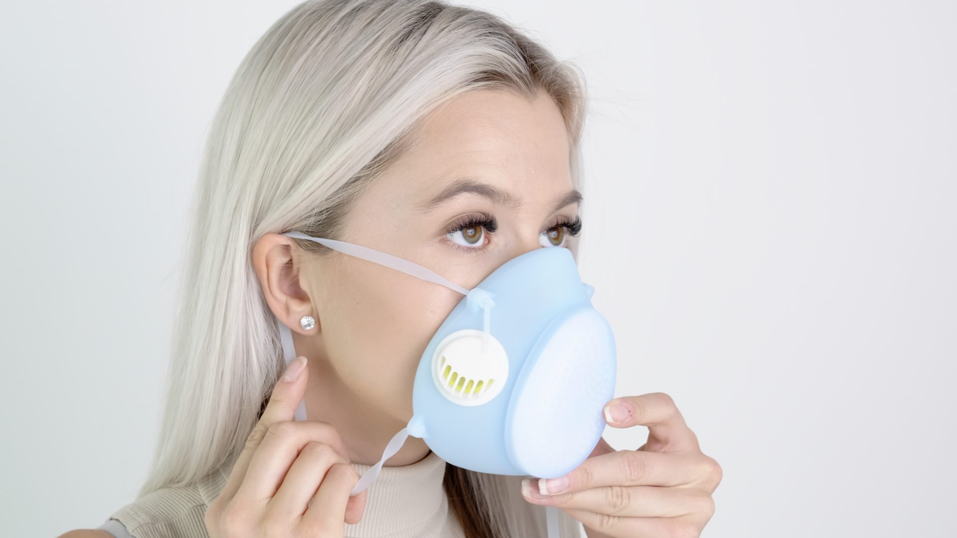 A woman wearing a blue Hygmask on a white background.