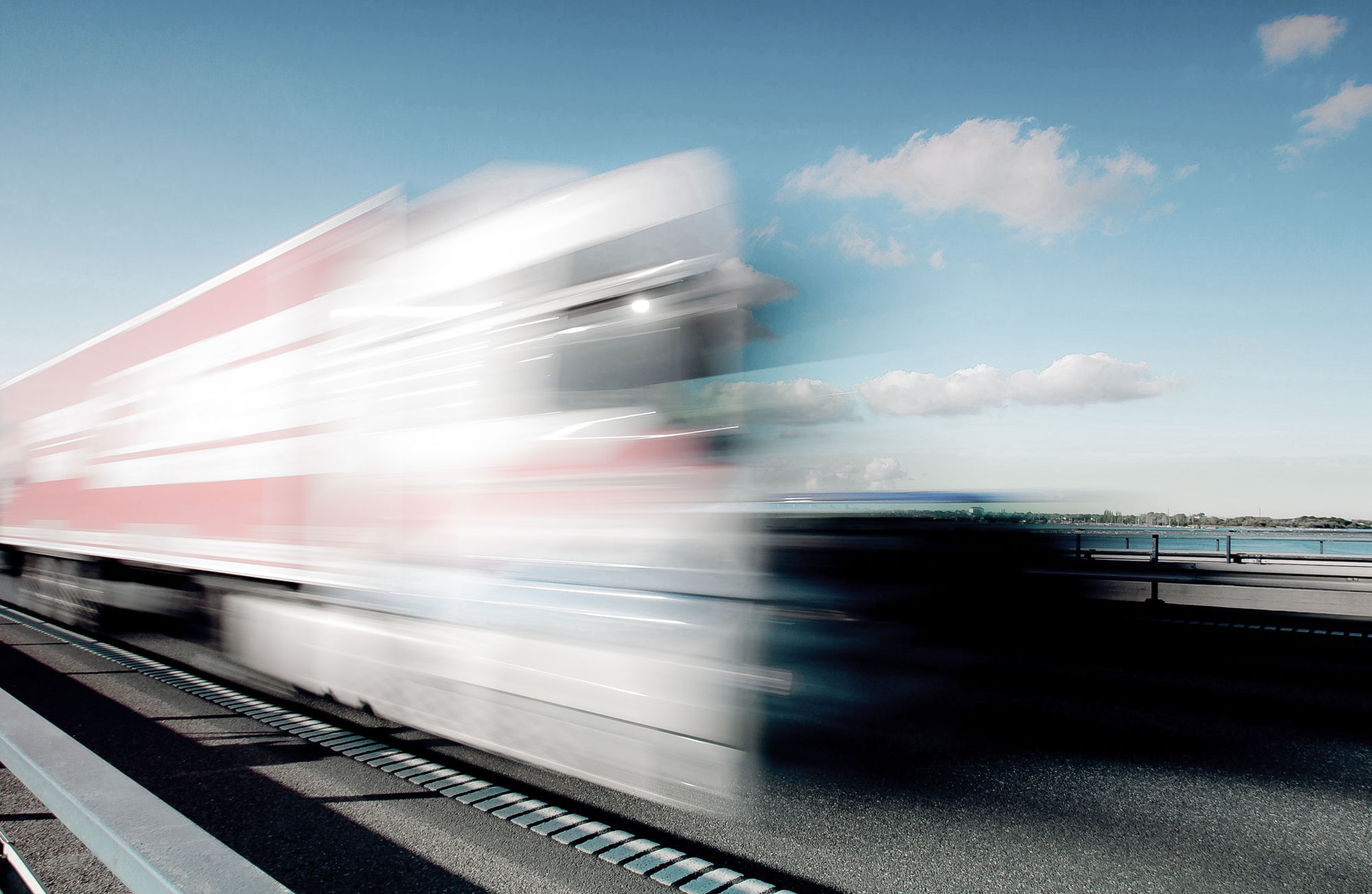 Ein roter LKW, der mit Intellic-Technologie auf einer Autobahn fährt.