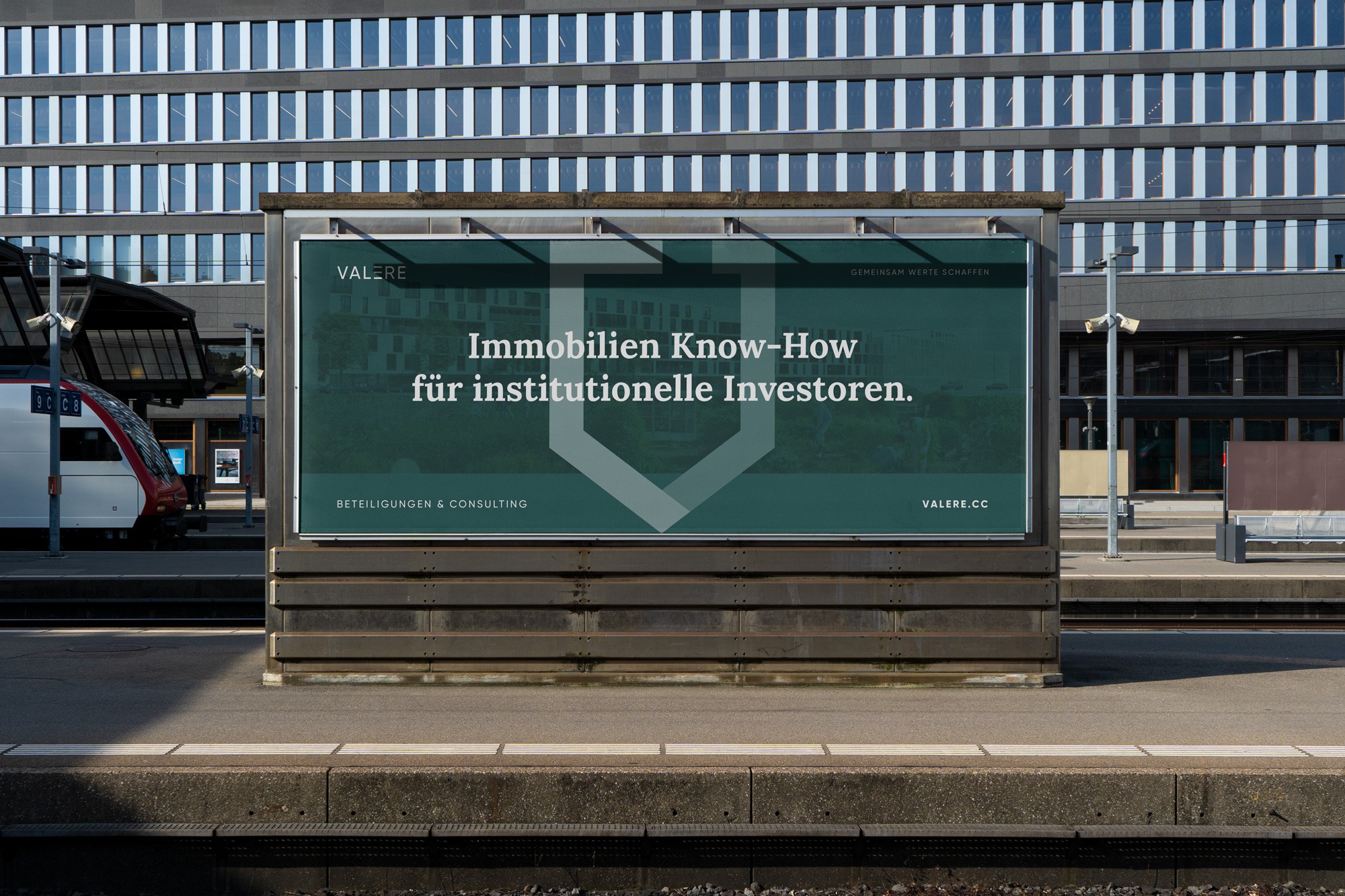 A train station with a Valere building in the background.