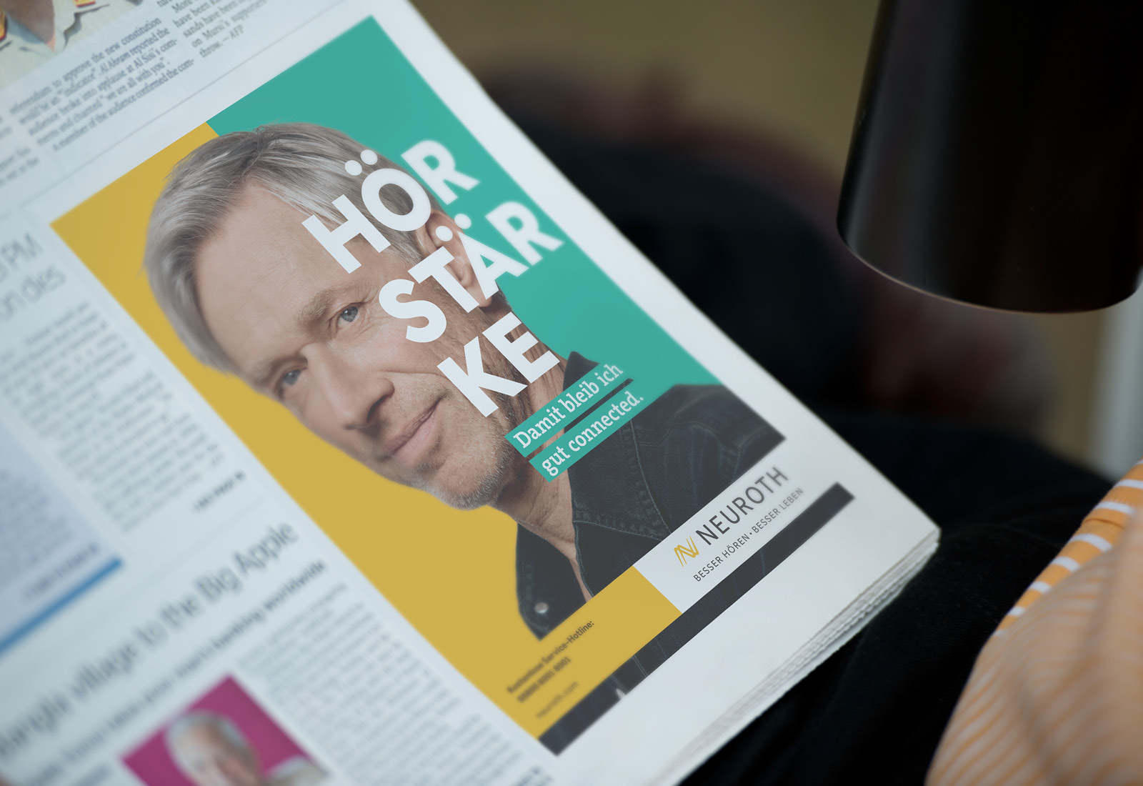 A man is reading a newspaper with a picture of a man.