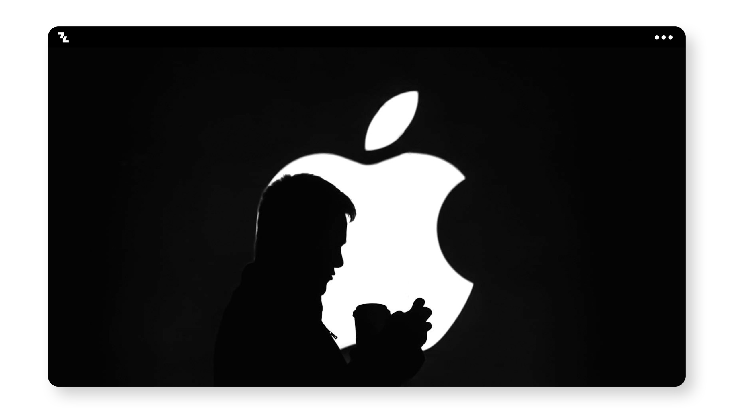 A silhouette of a man holding a phone in front of an apple logo.