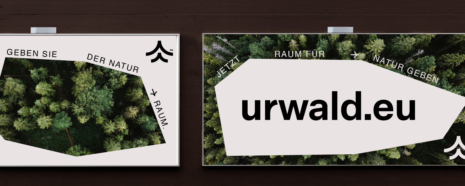 Zwei Plakate mit dem Wort urwald.eu darauf.
