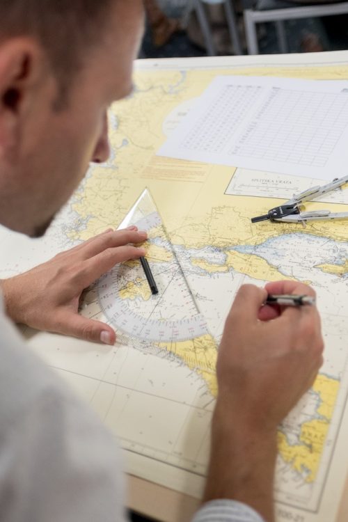 Ein Mann untersucht an einem Tisch eine Boote-Karte.