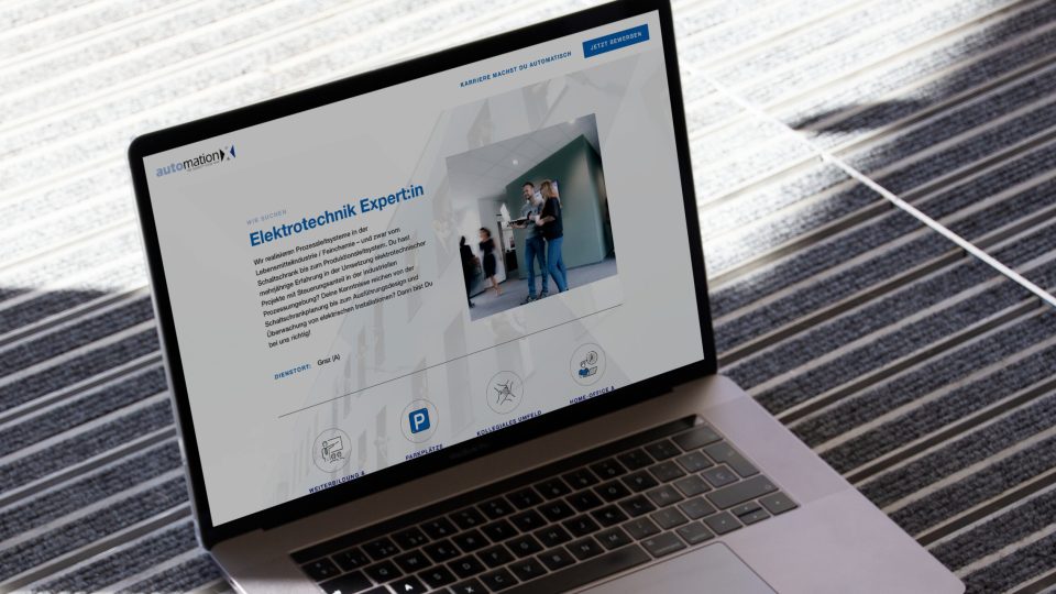 Auf einem Laptop wird die Startseite der Website von AutomationX angezeigt.