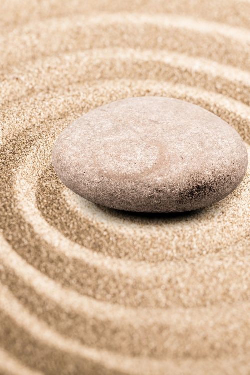 A stone sits in a circle of sand, created by Breitling+Partner.