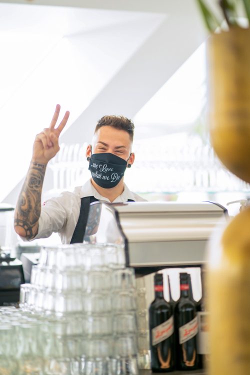 Ein Barkeeper im Freiblick Tagescafé mit Maske.