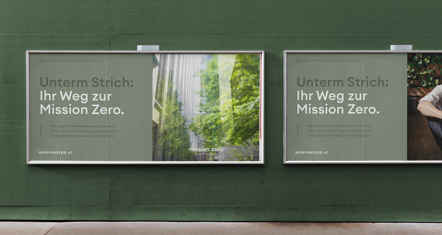 Zwei Werbetafeln, die für Mission Zero werben, an der Seite einer grünen Wand.