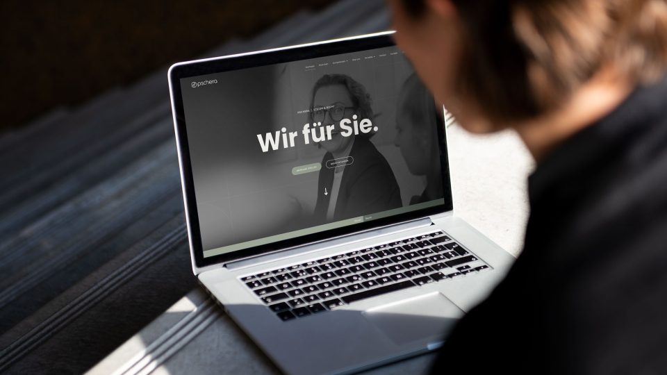 Eine Frau schaut auf einen Laptop mit der PMT-Website darauf.