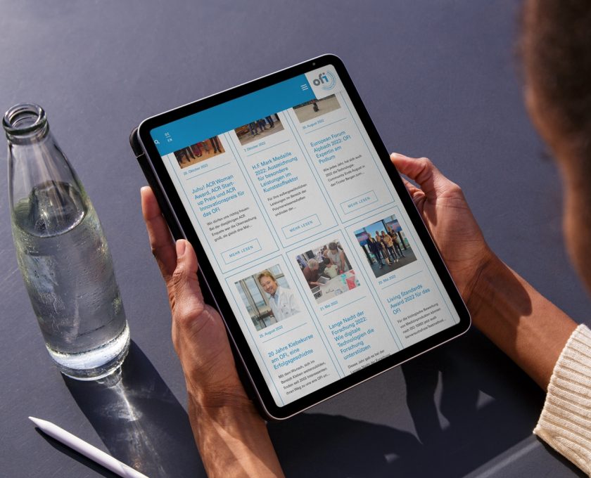 A woman is using an iPad to read a newspaper digitally.