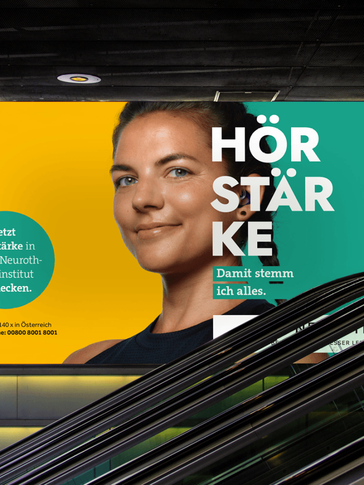 Eine Rolltreppe mit einer Werbung für Neuroth Hörgeräte.