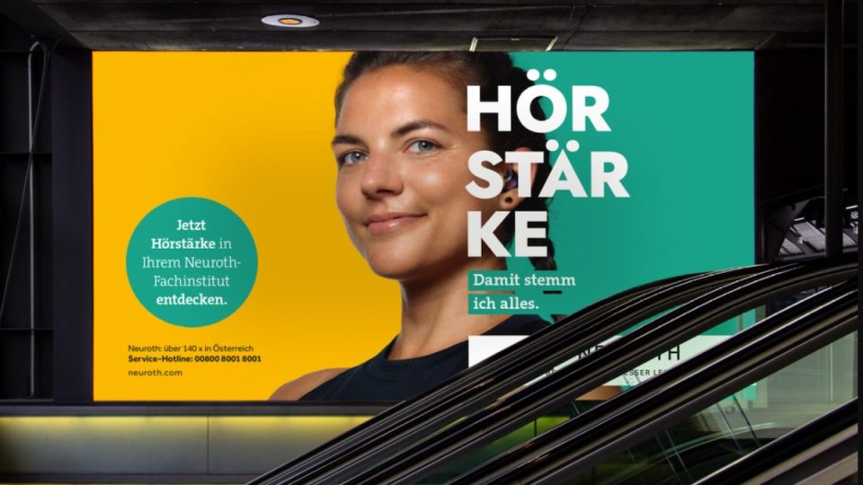 Eine Rolltreppe mit einer Werbung für Neuroth Hörgeräte.