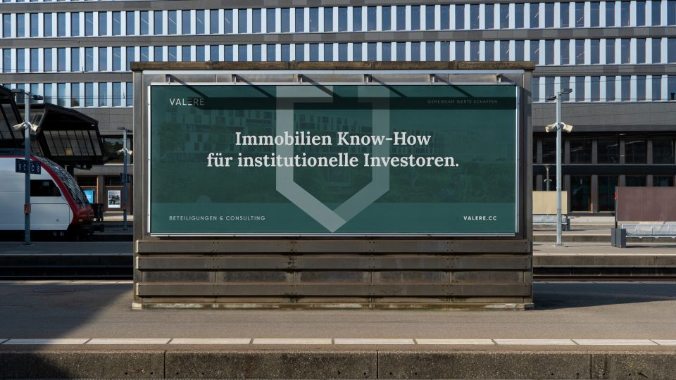 Ein Bahnhof mit einem Valere-Gebäude im Hintergrund.