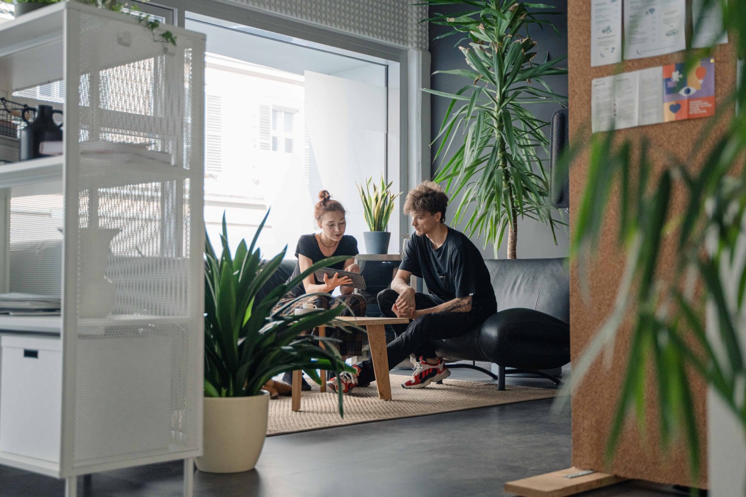 Zwei Personen in einem von Grün umgebenen Arbeitsplatz.