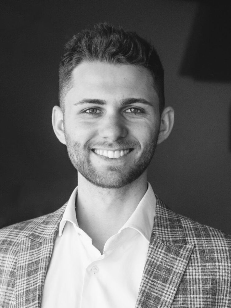 A black and white photo of a smiling man in a suit for web design company in Wien.