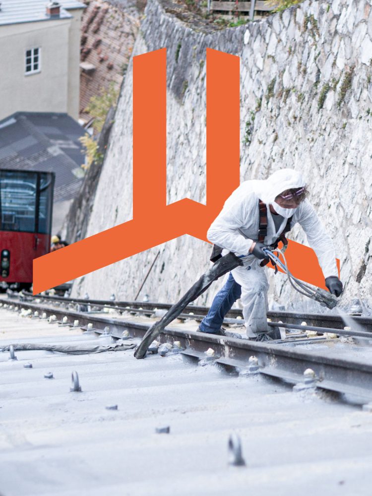 A man in a white jacket is working on a Polyflex train track.