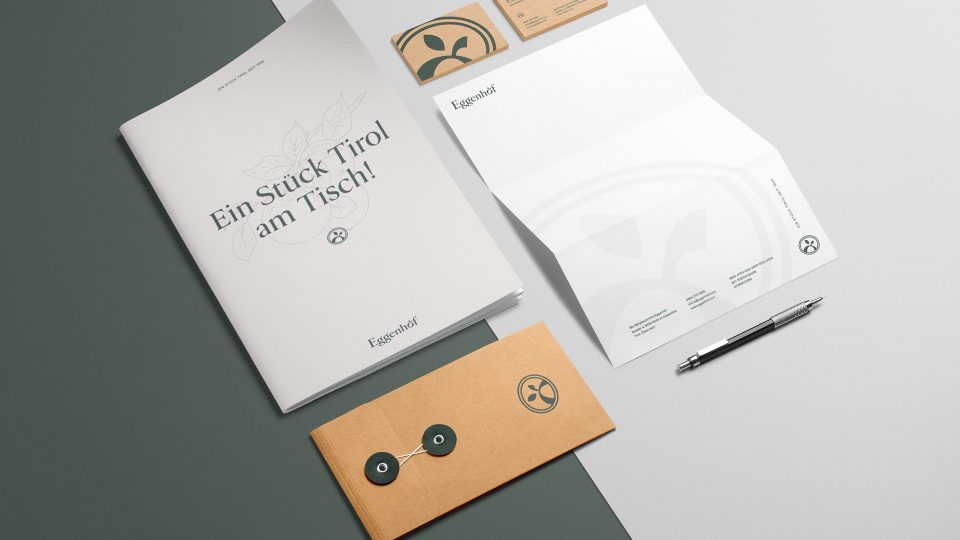 Ein Satz Visitenkarten und Briefpapier mit Eggenhof auf einem Tisch.