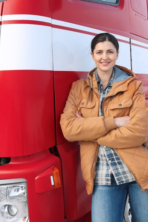 Eine Frau posiert vor einem roten Sattelschlepper.